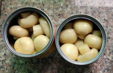 全体は小さいきのこ、缶詰にされたマリネされたきのこ薄黄色の色を缶詰にしました