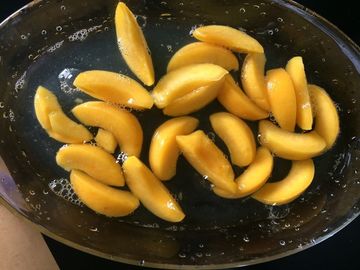 缶詰になった規則的な切れがモモ、容易な黄色いモモのフルーツをさいの目に切った425gは開きます